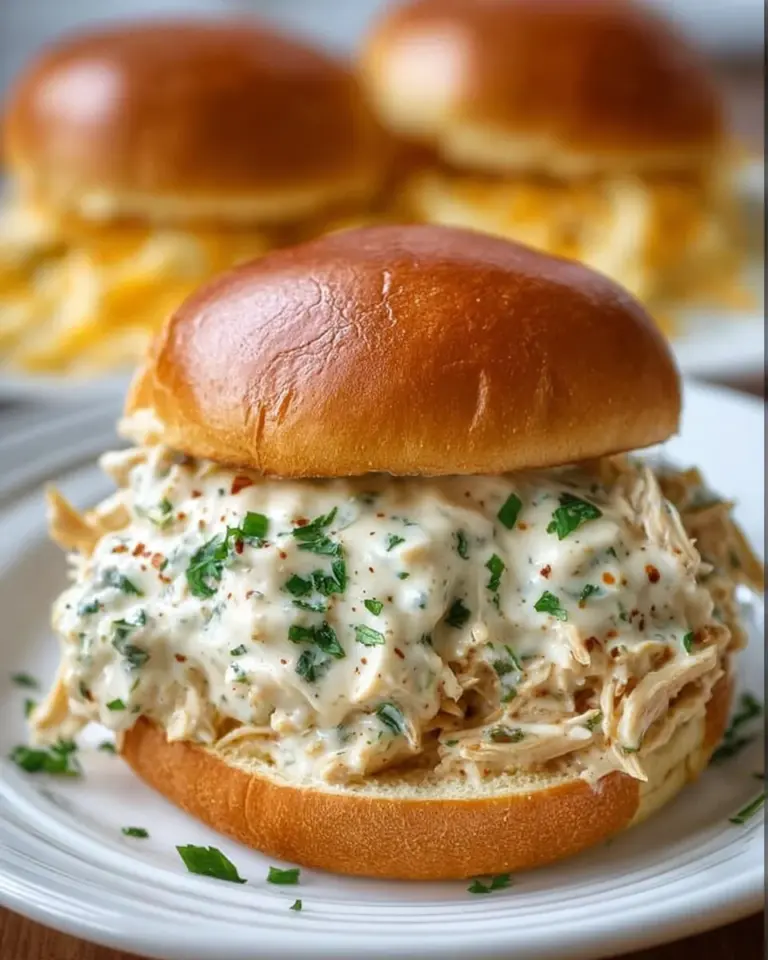 Chicken Alfredo Sloppy Joes topped with creamy sauce and cheese, comfort food dish.
