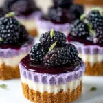 Mini blackberry lavender cheesecakes topped with fresh blackberries and lavender sprigs.